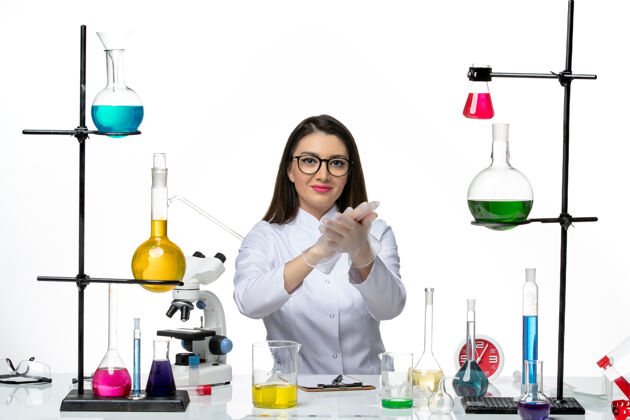 正面前视图穿着白色医疗服的女化学家正坐在一个白色背景的科学冠状病毒-实验室大流行病毒的解决方案实验室科学坐着