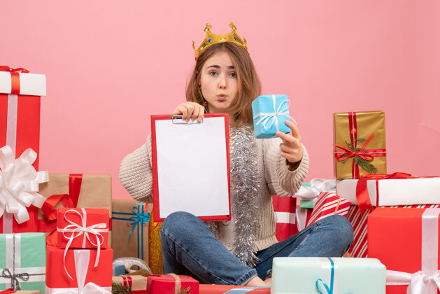 手正面图年轻女性围坐在礼物旁边 手里拿着纸条年份礼物圣诞节