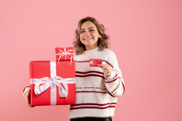 颜色正面图年轻女性手持圣诞礼物和银行卡抱着女人粉色