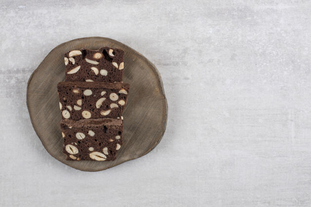 切片石头桌上放着棕色面包片和坚果的木板烹饪食品坚果
