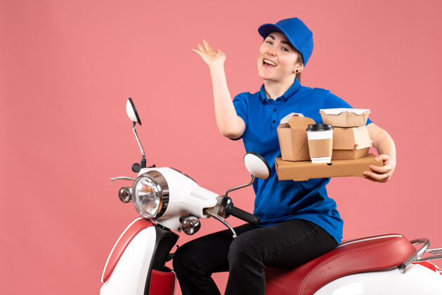 风景正面图女快递员带着食品包和盒子上粉红色的工彩送菜自行车制服服务人盒子工作