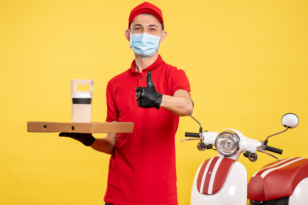 专业正面图：戴着口罩的男信使 带着咖啡和盒子 黄色工作服 彩色服务 病毒大流行工作服工作正面人