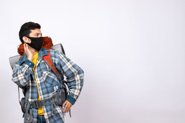运动正面图：背着背包和面具的男性旅行者正看着右边面具背包乐趣