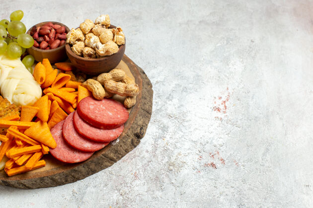 健康正面视图不同的零食坚果cips奶酪和香肠上的白色地板坚果零食餐食品食品香肠前面