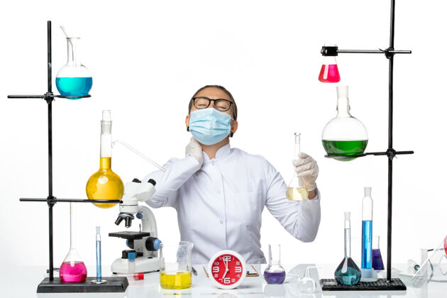 医学前视图：身穿白色医疗服的女化学家 带面罩 背景为浅白色化学家实验室病毒冠状病毒-飞溅前面化学家视图