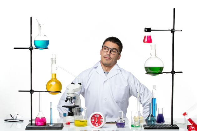 实验室前视图穿着白色医疗服的男性化学家坐在一个白色背景病毒科学冠状病毒-大流行实验室准备工作病毒科学工作