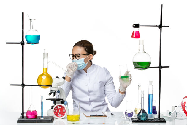 持有前视图穿着医疗服的女化学家 白色背景上有面罩保持液飞溅实验室病毒化学covid-实验室药物解决方案