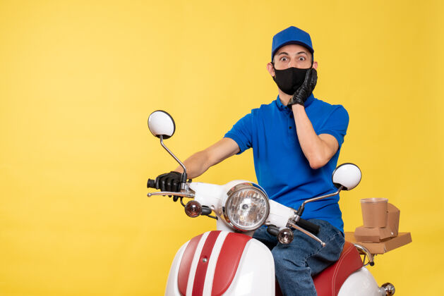 自行车正面图身穿蓝色制服 戴着黄色自行车面罩的男性快递员大流行工作病毒-工作病毒传递运动球员流行病