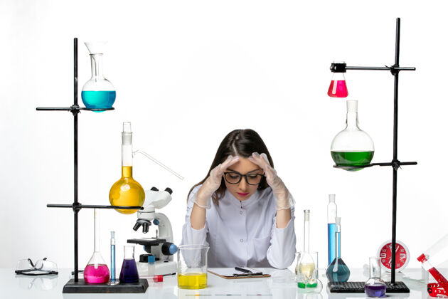 周围前视图穿着医疗服的女化学家围坐在桌子旁 在浅白色背景上提供解决方案实验室病毒冠状病毒大流行科学实验套装科学