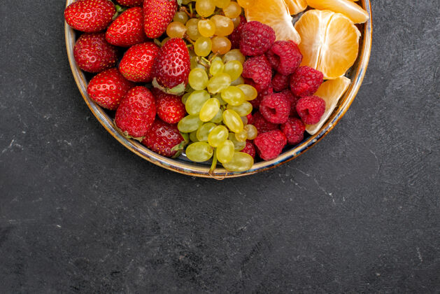农产品顶视图水果成分草莓葡萄覆盆子和柑橘托盘内的黑暗空间食品内部托盘