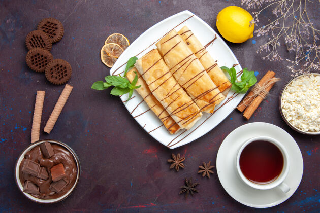 早餐在黑暗的空间里俯瞰美味的甜点和一杯茶和巧克力巧克力盘子糖