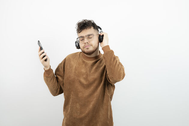 男人戴着耳机的年轻人用手机选歌男性眼镜歌曲