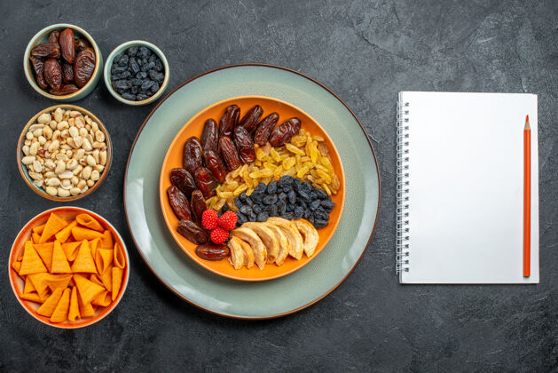 碗顶视图干果与不同的葡萄干和零食的灰色空间水果盘子胡椒