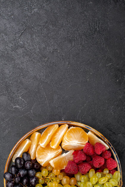 水果顶视图水果成分草莓葡萄覆盆子和柑橘托盘内的黑暗空间草莓食物覆盆子