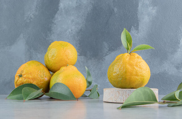 配料大理石上的一小堆橘子和树叶健康有机营养