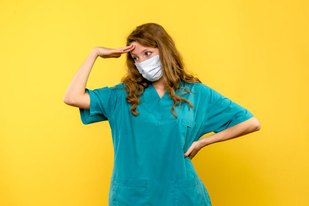 药黄色墙壁上戴着面具的女医生的正视图保健黄色职业