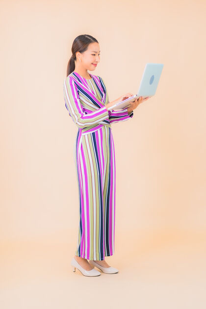 中国人用彩色笔记本电脑描绘美丽的亚洲年轻女子无线数据工作