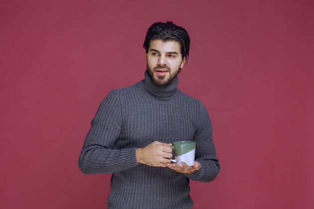 姿势穿着灰色毛衣的男人手里拿着一个咖啡杯高质量的照片休息员工男性