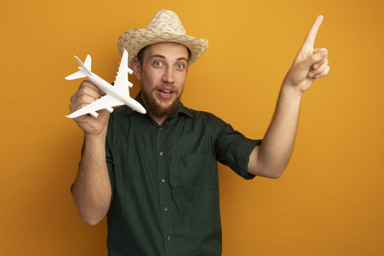 市民一个戴着沙滩帽的金发帅哥拿着飞机模型 孤零零地指着橙色的墙上男人金发印象