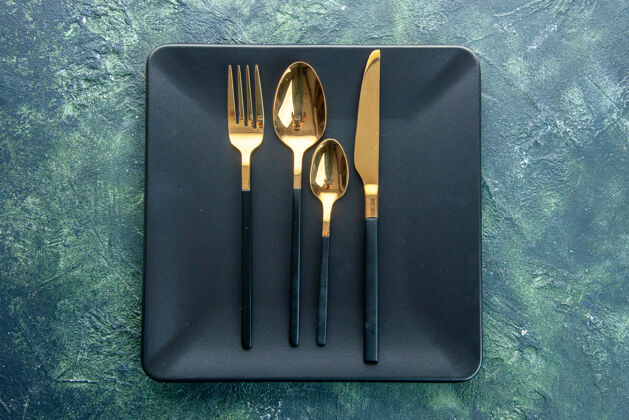 视图顶视图黑色盘子 带金色勺子刀叉 背景颜色为深色食物晚餐厨房餐厅餐具设备笔记本工具箱