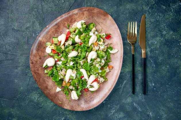 午餐顶视图新鲜蔬菜沙拉内优雅的盘子与餐具在深蓝色表面健康午餐美食餐厅颜色餐减肥食品烹饪颜色食物