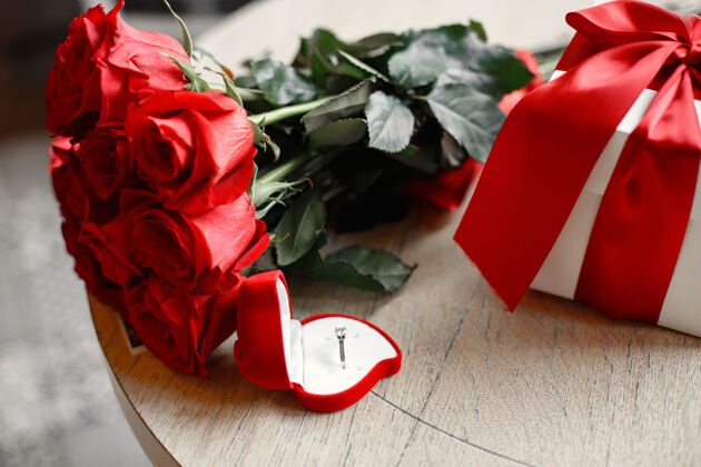 情人节女孩手指上的结婚戒指一束红玫瑰订婚礼物玫瑰礼物红色