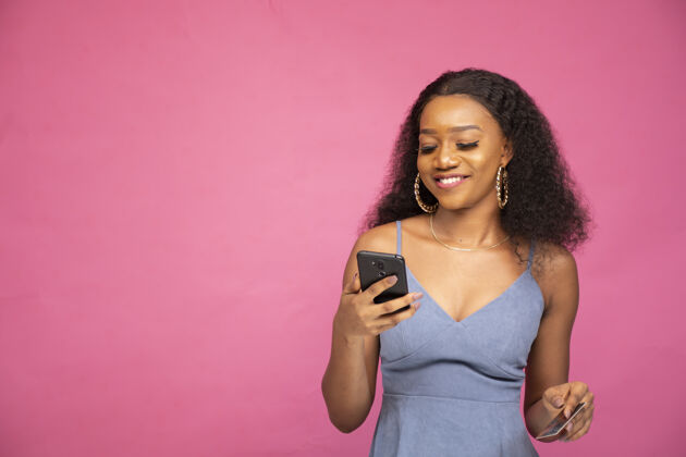 年轻年轻的非洲女性用她的智能手机在线购物尼日利亚快乐使用