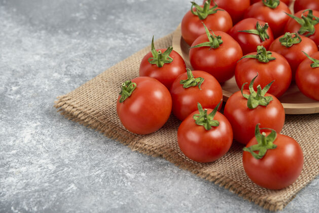 烹饪一堆红色的新鲜西红柿 用麻袋布铺在大理石表面多汁的天然红色