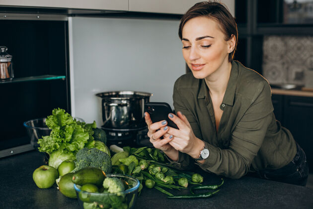 绿色蔬菜女人在厨房打电话 用绿色蔬菜做饭营养女性女人
