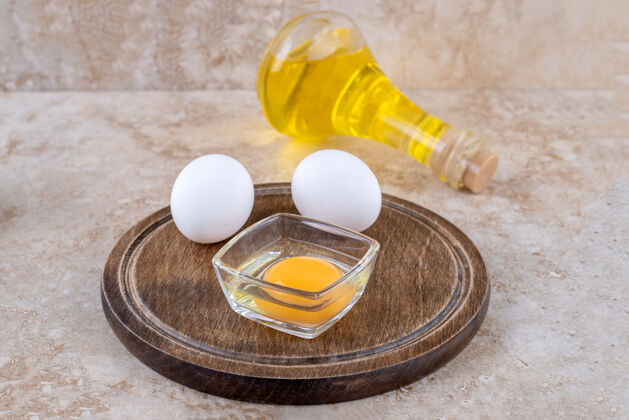 蛋白质一块生鸡蛋木板和一瓶玻璃油鸡蛋美味食物