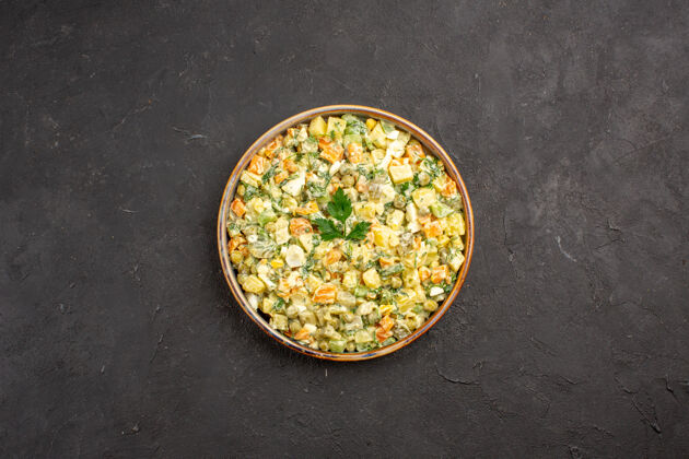 食物蛋黄酱沙拉的俯视图 深色表面有不同的蔬菜黑碗谷物