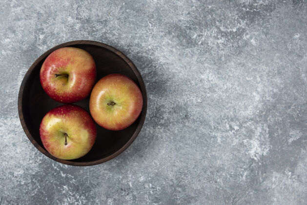 苹果在大理石表面放上一碗鲜亮的苹果营养明亮美味