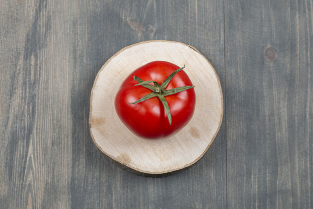 扁的一整只多汁的番茄放在木桌上圆的生的扁的