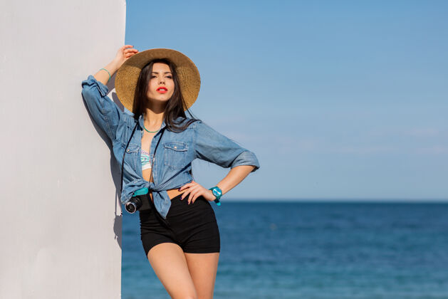 太阳穿着短裤戴着草帽在沙滩上摆姿势的漂亮女人天空眼睛海滨