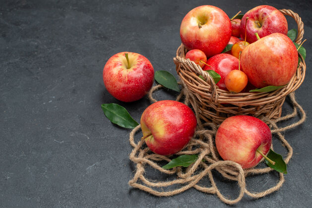 苹果侧面特写查看篮子里的水果樱桃和苹果绳多汁根类蔬菜萝卜