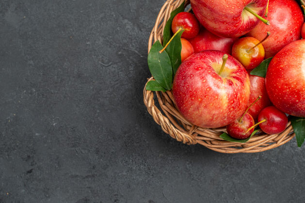 浆果顶部特写查看水果苹果和浆果在篮子在黑暗的桌子上深色健康根类蔬菜
