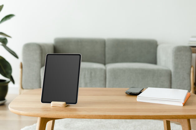手机数字平板电脑与木桌上的空白屏幕未来客厅房子
