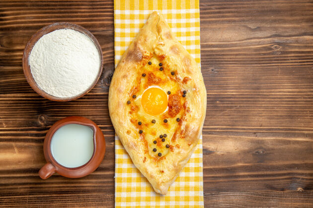 生的顶视图美味的鸡蛋面包新鲜出炉 牛奶放在木桌上 面团烤面包 包蛋新鲜晚餐风景