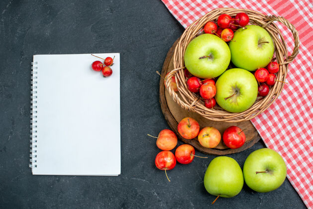 饮食顶视图篮子上有水果绿色的苹果和甜樱桃 表面呈深灰色 果实由浆果组成 新鲜度高顶部可食用水果篮子