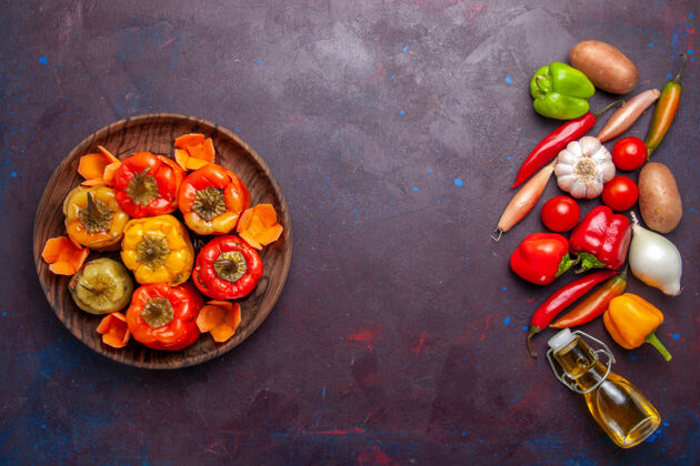 饮食顶视图煮熟的甜椒与新鲜蔬菜在黑暗的表面一餐蔬菜食品肉多尔玛烹饪生的新鲜