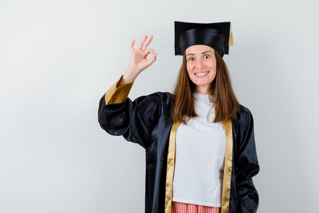 证书毕业的女人 穿着休闲服 穿着校服 看起来很愉快 正面照教育多样性欢呼