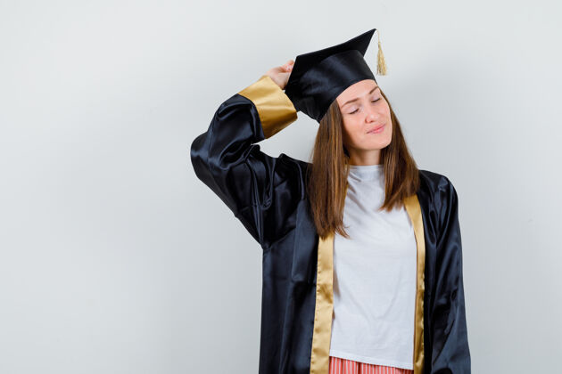 女女毕业生身着制服 手举在头上摆姿势的肖像 穿着休闲服 看起来很迷人成就长袍提高