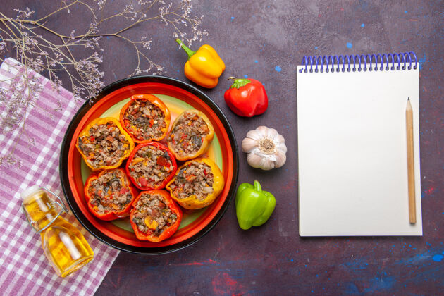 午餐顶视图煮熟的甜椒与地面肉和油在黑暗的表面蔬菜食品肉多尔玛容器蔬菜托盘