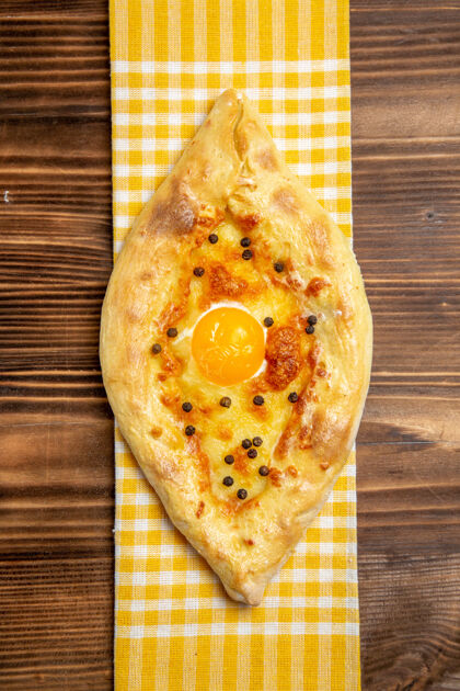 小吃俯视图美味的鸡蛋面包刚从烤箱里拿出来放在木头桌子上吃面包包早餐鸡蛋膳食鸡蛋早餐