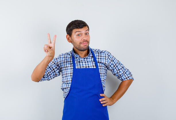 年轻穿着蓝色围裙和衬衫的年轻男厨师男士衬衫男士