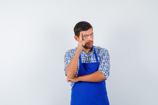 烹饪穿着蓝色围裙和衬衫的年轻男厨师制服男士衬衫