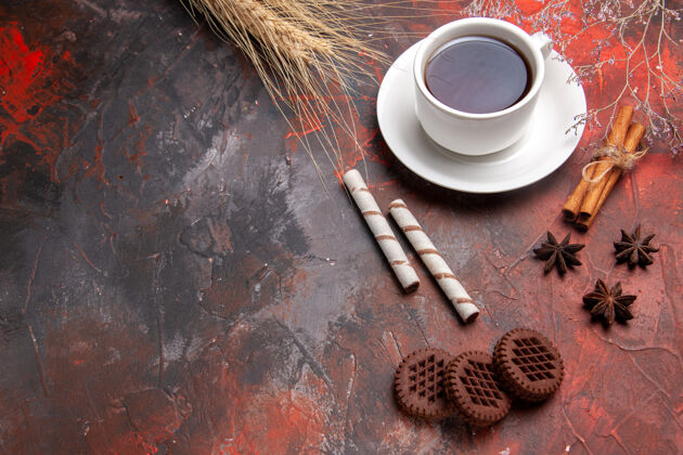 茶顶视图一杯茶加巧克力饼干放在黑桌子上茶饼干饼干香味茶杯杯子