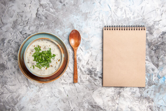 纸俯瞰美味的dovga酸奶汤与绿色的白色餐桌牛奶汤菜乳制品木勺酸奶食物