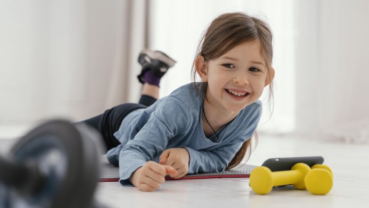 孩子全拍笑脸女孩在垫子上健身生活方式训练