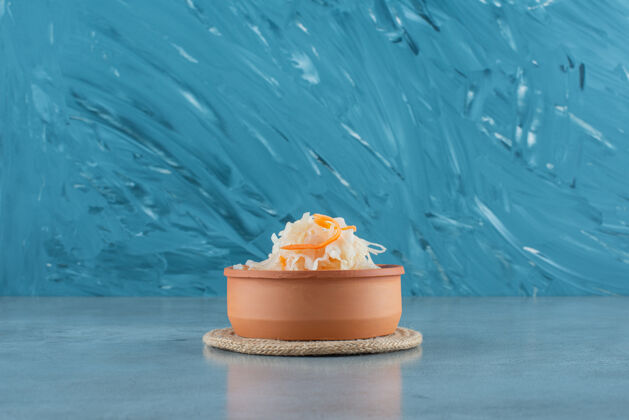 美味在蓝色表面的三角架上 碗里放着胡萝卜发酵泡菜碗胡萝卜排骨